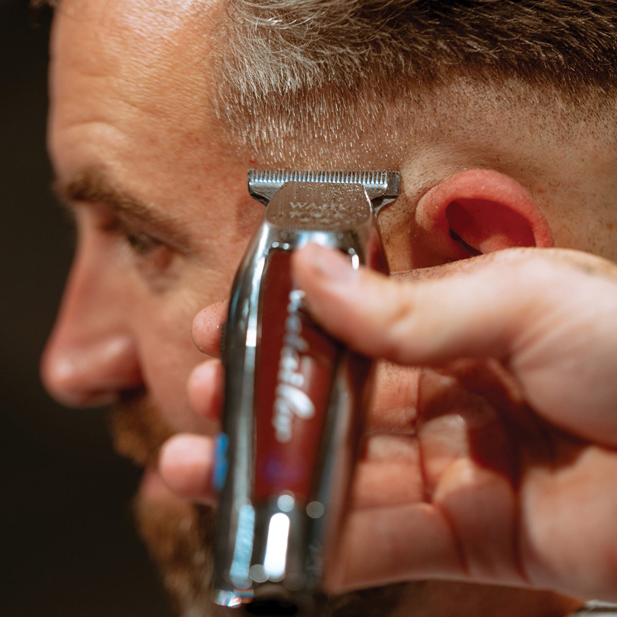 Närbild: Wahl Cordless Detailer med T-blad trimmar kanten vid örat
